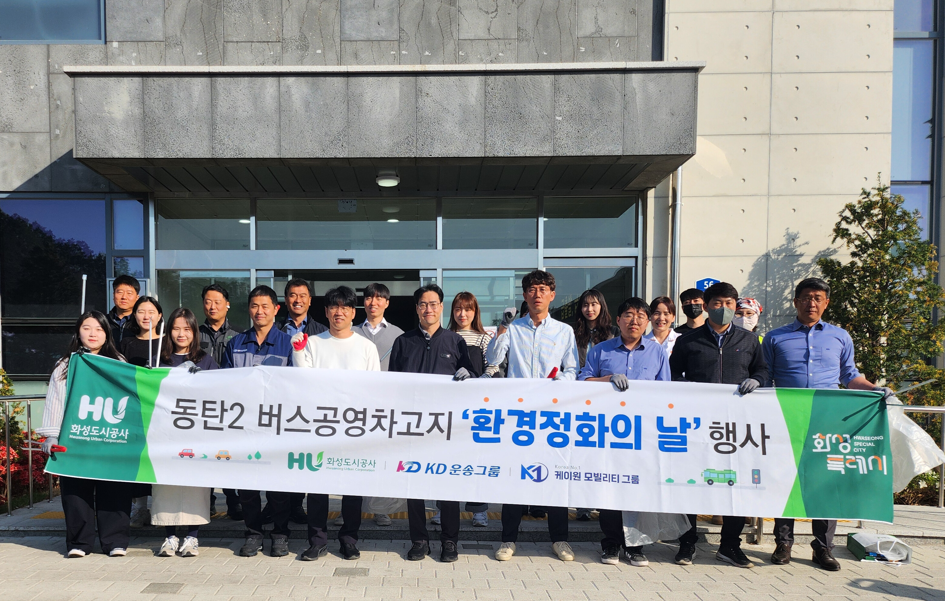 HU공사 및 버스공영차고지 입주기관 임직원들이 봄맞이 환경정화를 시행하며 단체 사진을 찍고 있다.